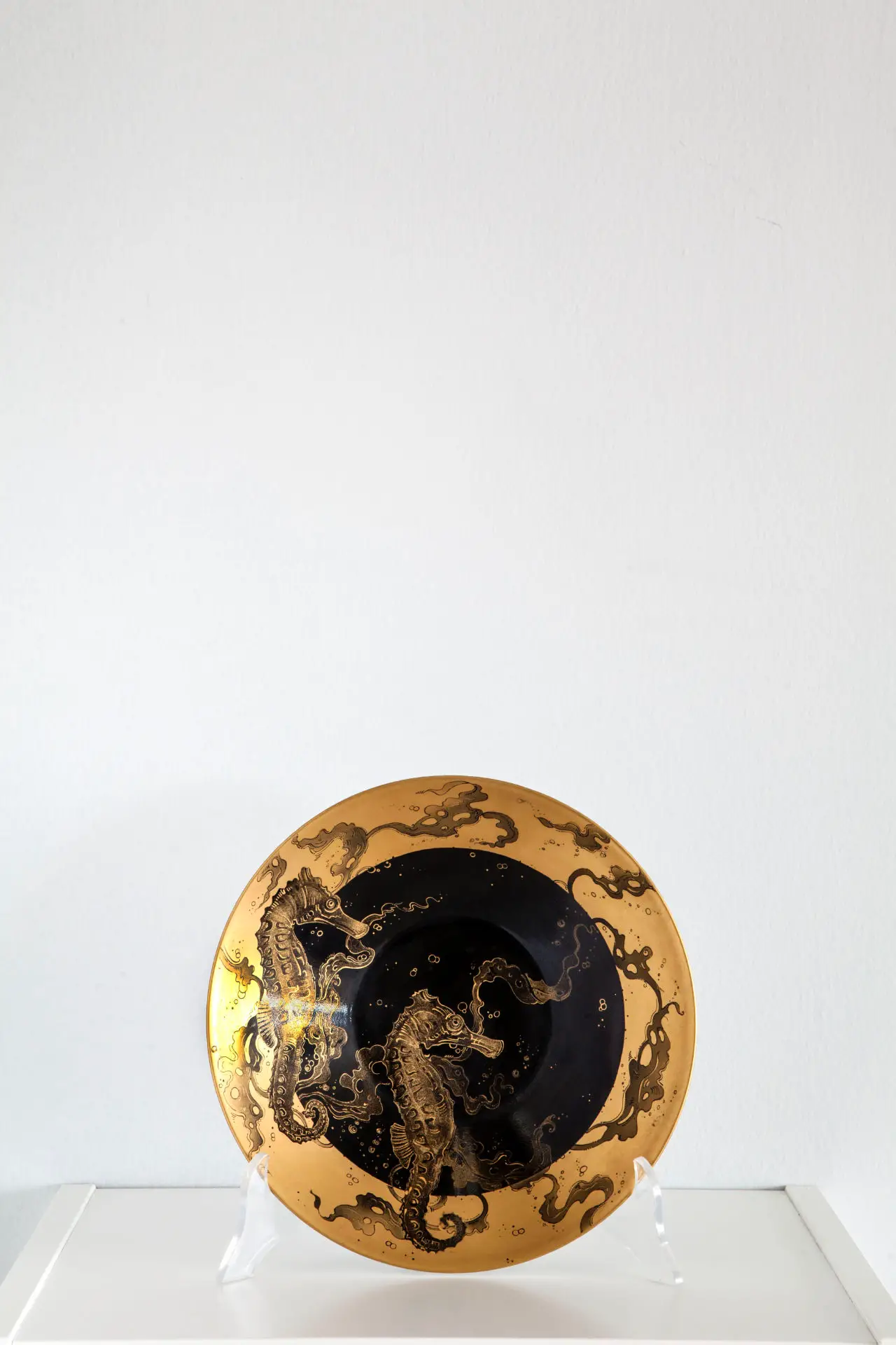Una de las porcelanas pintadas por Ely Phenix con varios caballitos de mar dorados
